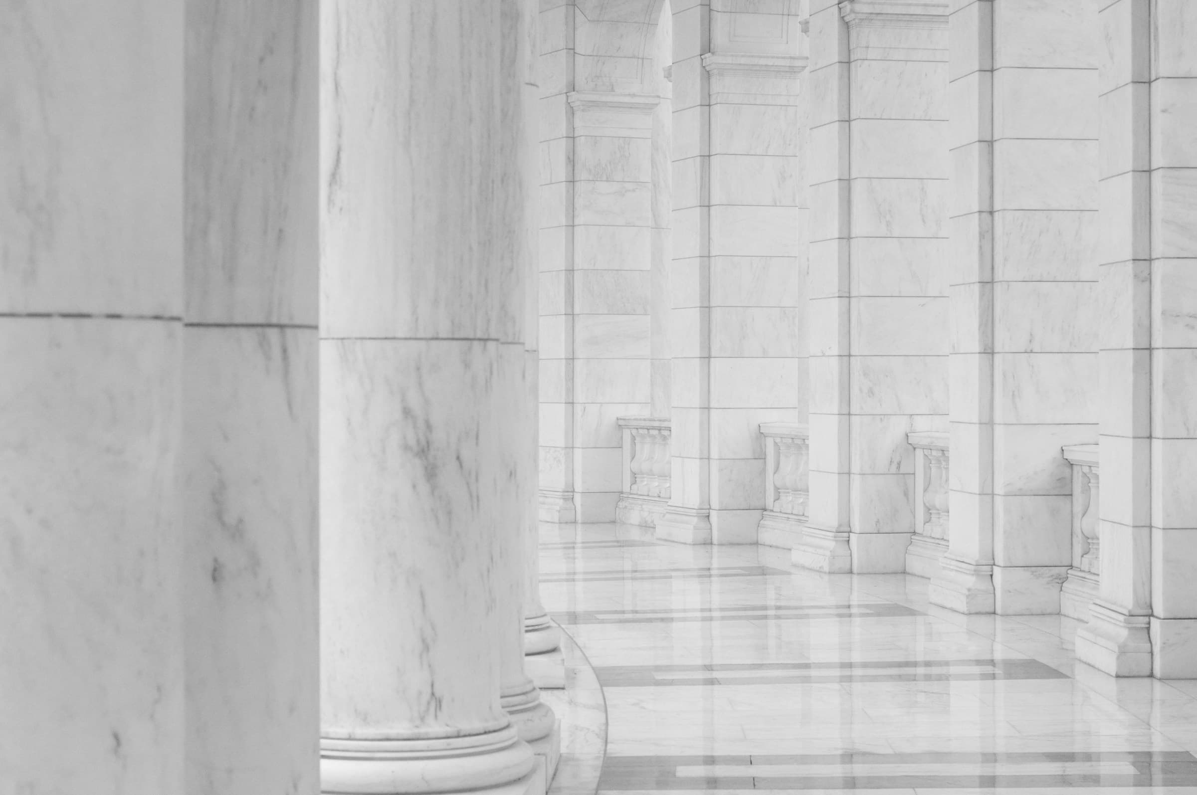 A marble colonnade receding down a long corridor